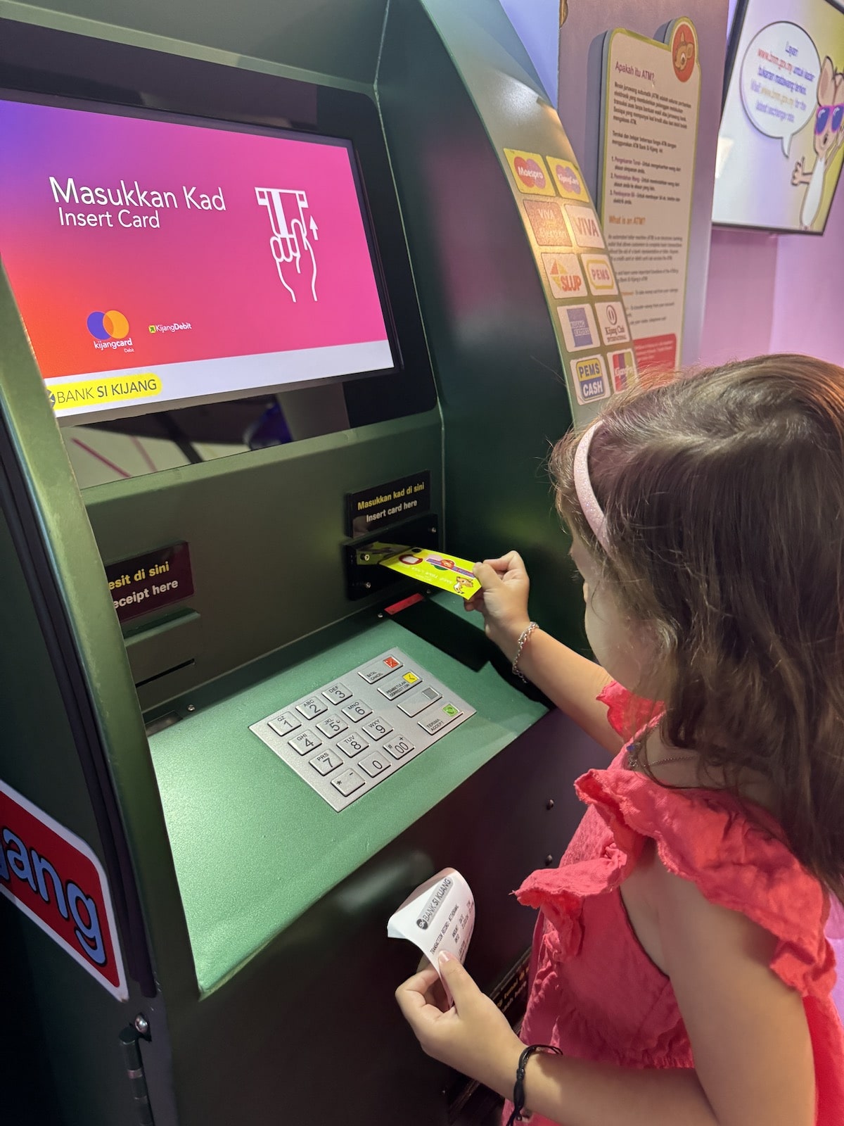 Little girl at an ATM in Children's Gallery of Bank Negara Malaysia Museum